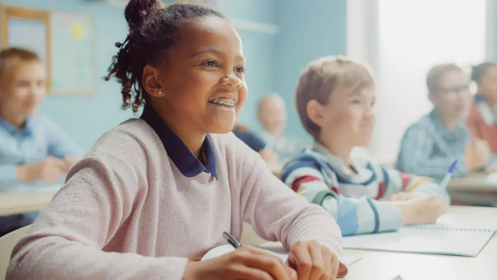 Young girl smiling with braces in class